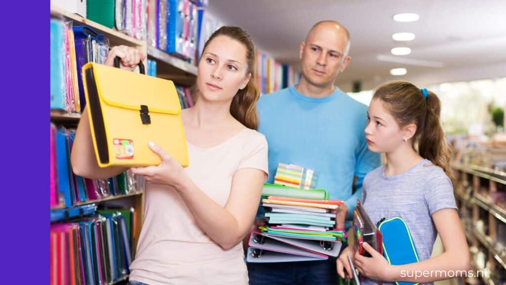Ouders met tiener kiezen samen schoolspullen uit in de winkel