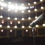 Microfoon op een podium in een theaterzaal, symbool voor de Glee reboot op Disney+